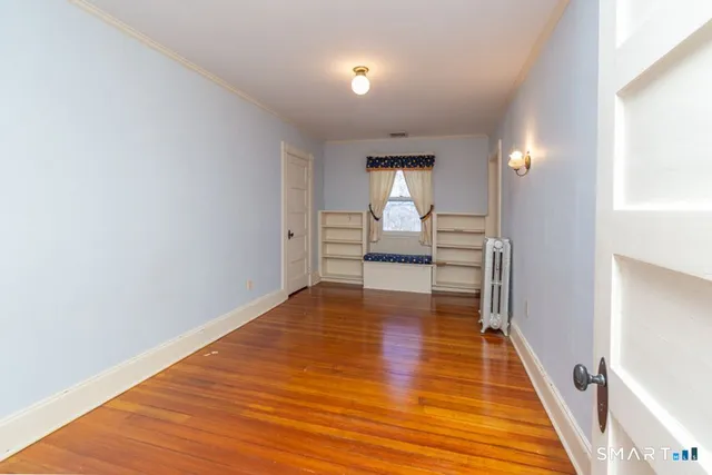a view of empty room with wooden floor
