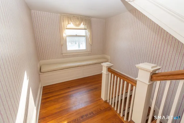 a view of a hallway with stairs and wooden floor