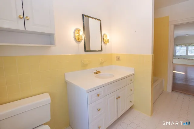 a bathroom with a sink a toilet and a mirror