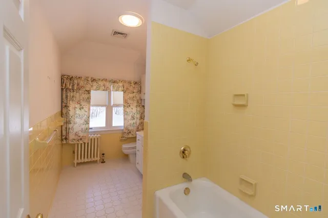 a bathroom with a tub sink and mirror