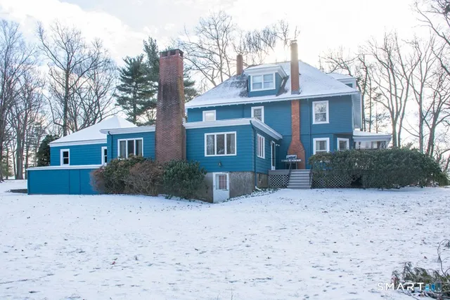 a front view of a house with a yard covered in snow