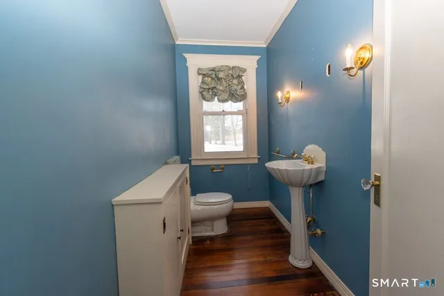 a bathroom with a sink toilet and a window