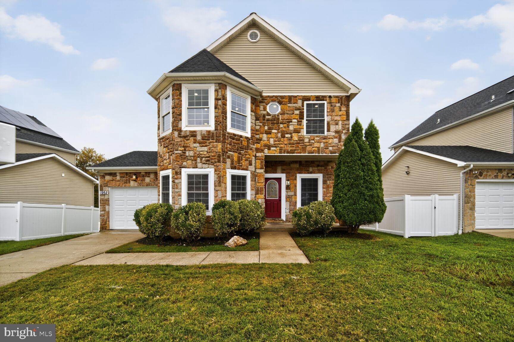 Charming stone-front home with lush greenery.