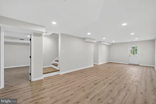 a view of empty room with wooden floor