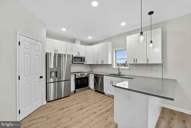 a kitchen with granite countertop a refrigerator and a sink