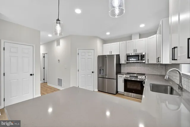a kitchen with stainless steel appliances a refrigerator sink and stove