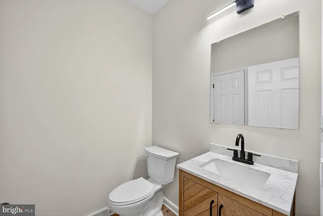 a bathroom with a sink a toilet and mirror