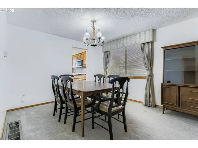 a view of a dining room with furniture and a chandelier