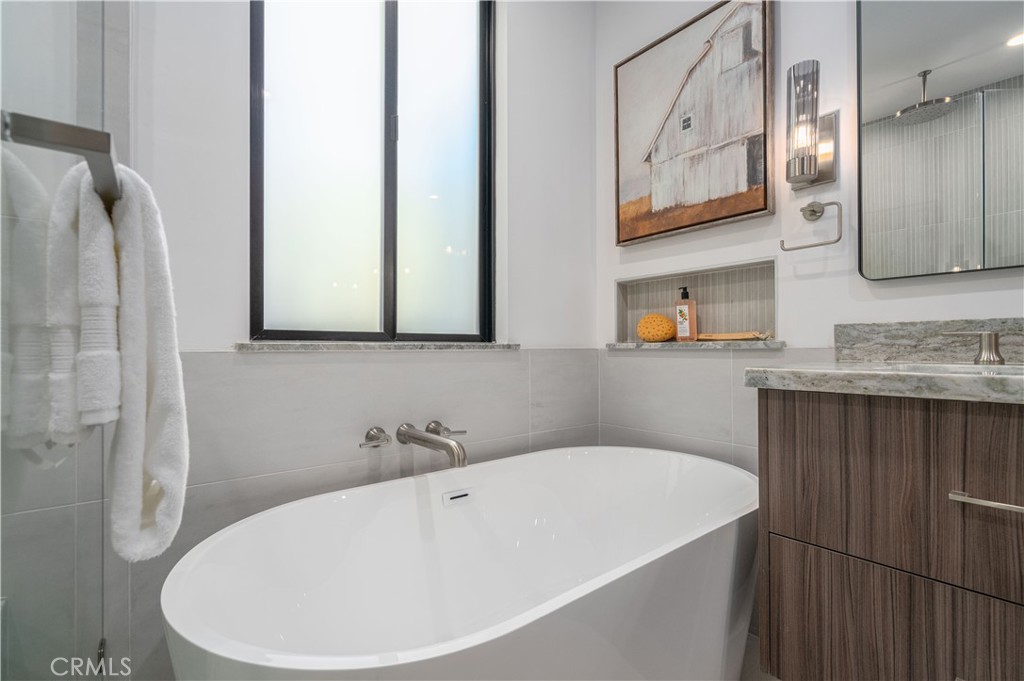 2101 Rockefeller Lane Redondo Beach, CA 90278 - Photo 24 of 45 a bathroom with a white bath tub a sink and a large mirror