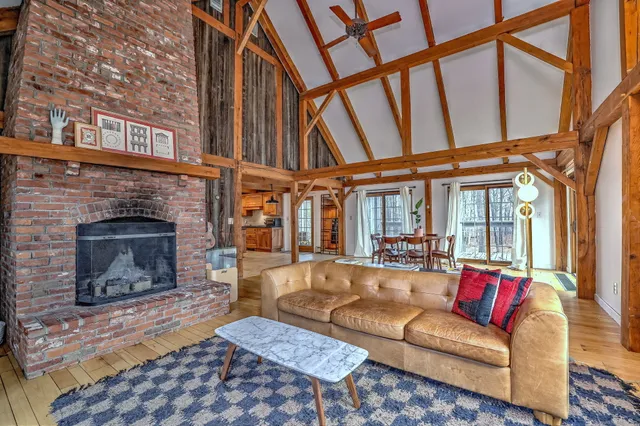 a living room with furniture a fireplace and a floor to ceiling window