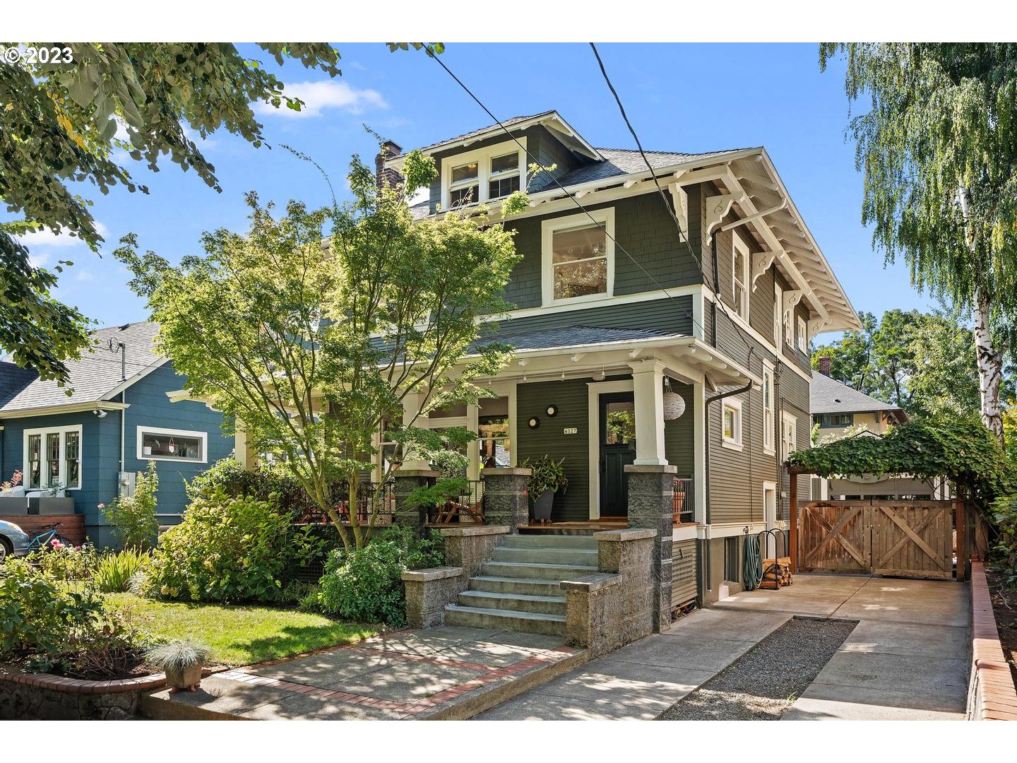 a view of a white house with large windows and a table and chairs
