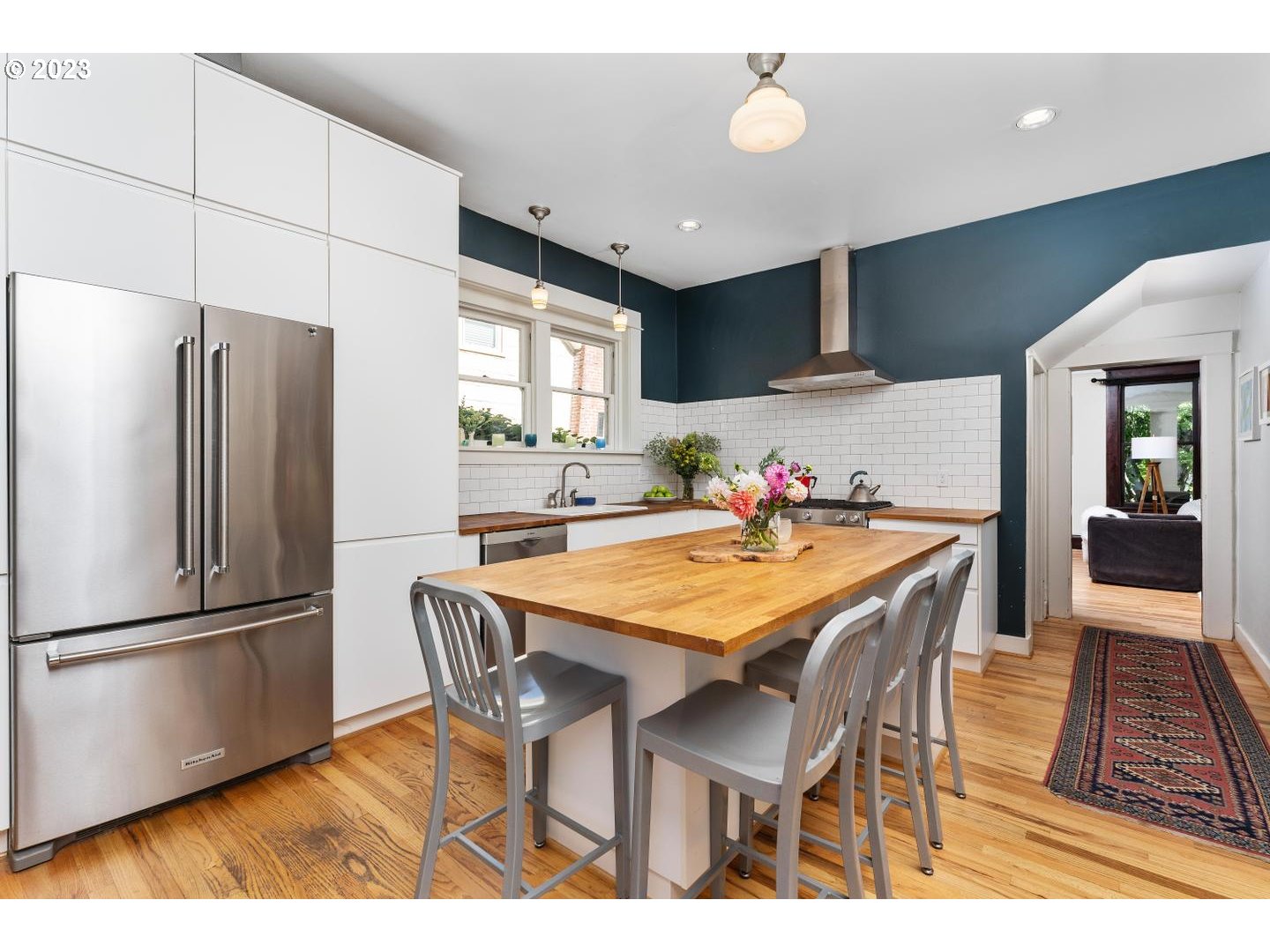 4027 North Colonial Avenue Portland, OR 97227 - Photo 12 of 47 a kitchen with stainless steel appliances granite countertop a dining table chairs refrigerator and sink