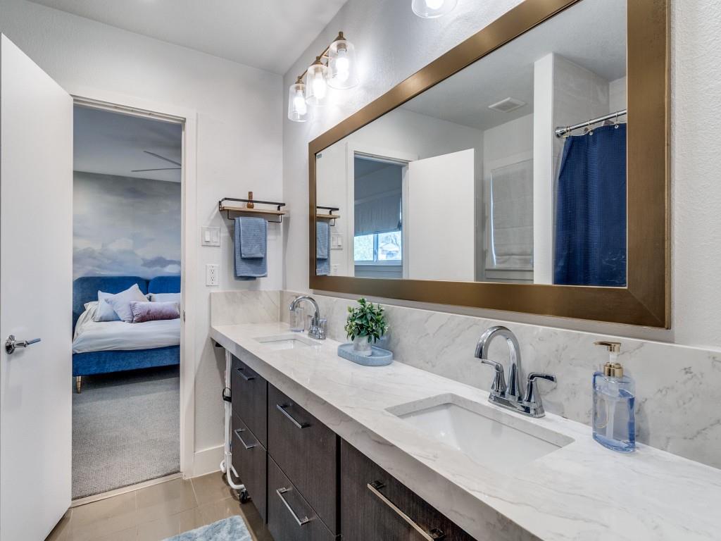7326 Spring Valley Road Dallas, TX 75254 - Photo 19 of 25 Bathroom featuring double vanity, connected bathroom, and curtained shower