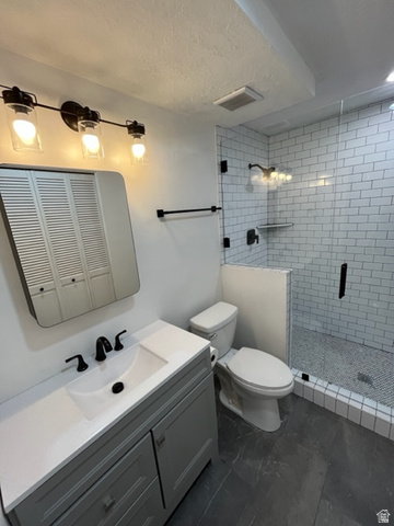 6884 670 East Midvale, UT 84047 - Photo 14 of 28 Bathroom with vanity, a stall shower, a textured ceiling, and a closet