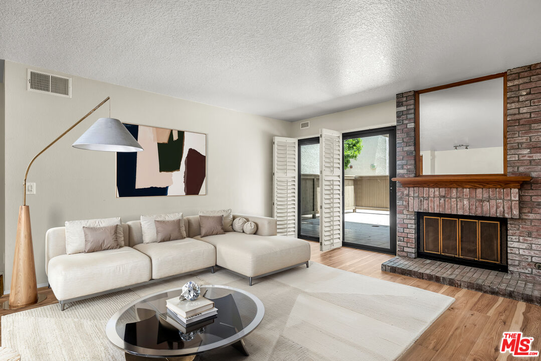8512 Tuscany Avenue, Unit 207 Playa del Rey, CA 90293 - Photo 1 of 45 a living room with furniture and a fireplace