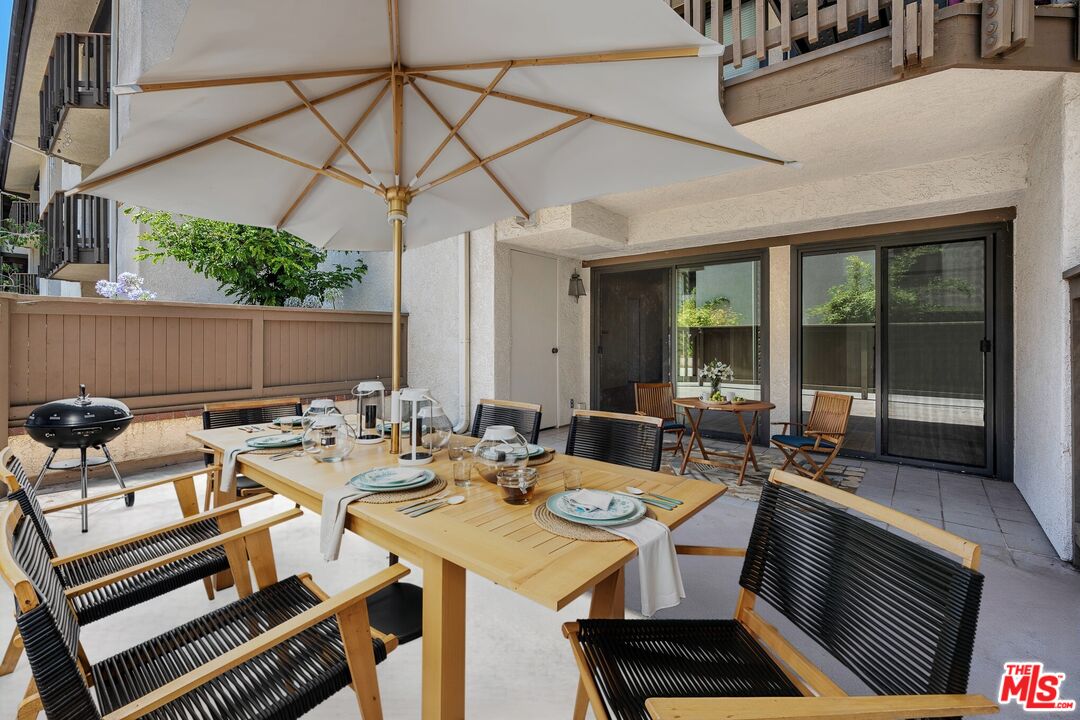 8512 Tuscany Avenue, Unit 207 Playa del Rey, CA 90293 - Photo 14 of 45 a view of a patio with table and chairs with barbeque grill and wooden floor