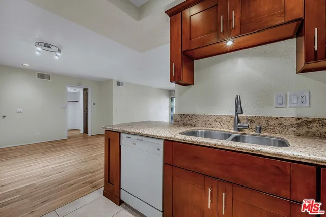 a kitchen with granite countertop a sink and cabinets