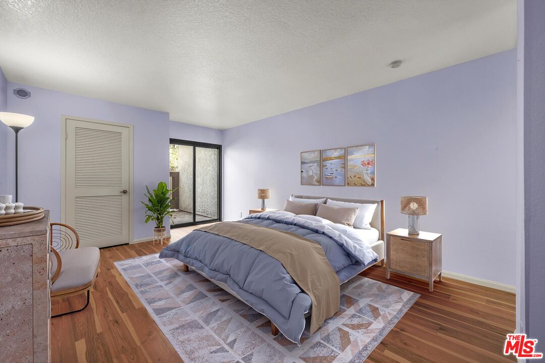 8512 Tuscany Avenue, Unit 207 Playa del Rey, CA 90293 - Photo 22 of 45 a bedroom with a large bed and wooden floor