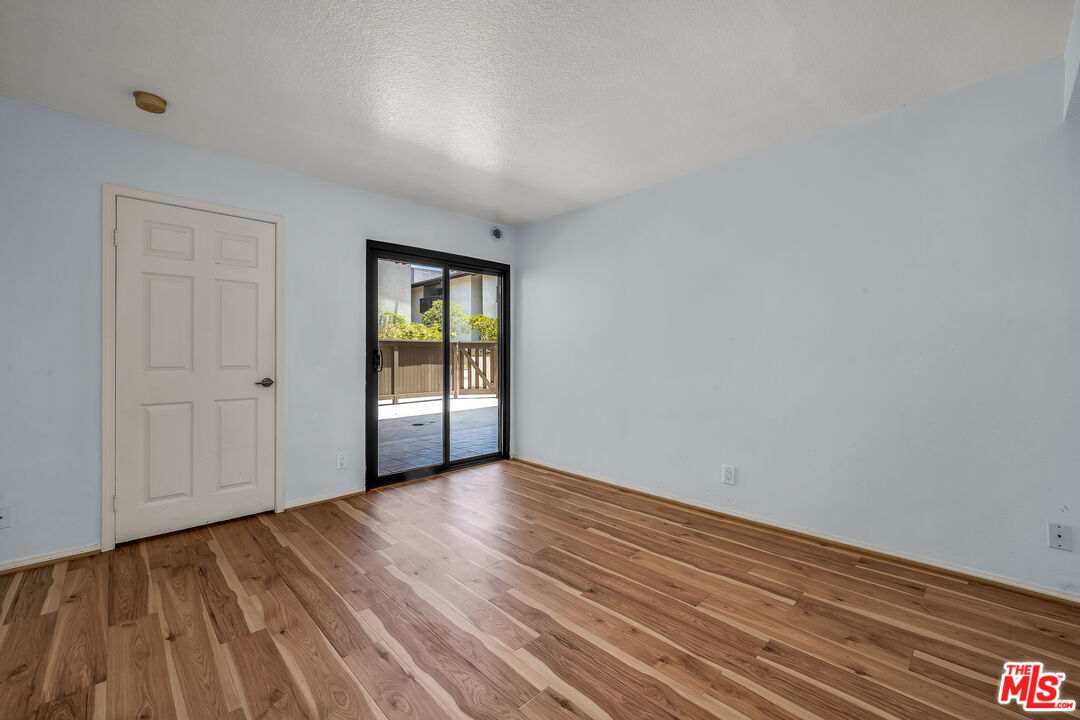 8512 Tuscany Avenue, Unit 207 Playa del Rey, CA 90293 - Photo 31 of 45 a view of an empty room with wooden floor and a window