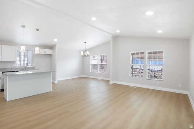 332 Hillgate Way Layton, UT 84041 - Photo 6 of 26 Unfurnished living room with light wood-style flooring, hanging lights, and beamed ceiling