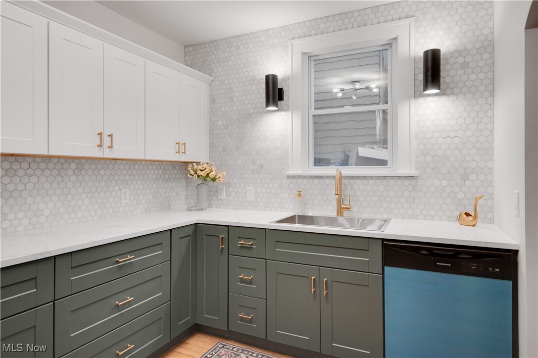 2016 Rossmoor Road Cleveland Heights, OH 44118 - Photo 17 of 46 Kitchen with dishwasher, white cabinets, light stone counters, light wood-type flooring, and decorative backsplash