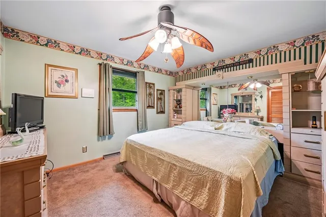 a spacious bedroom with a bed and a flat screen tv