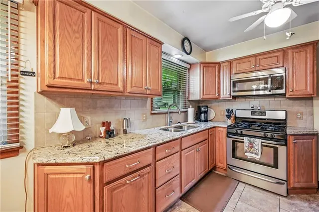 a kitchen with stainless steel appliances granite countertop a stove sink microwave and cabinets
