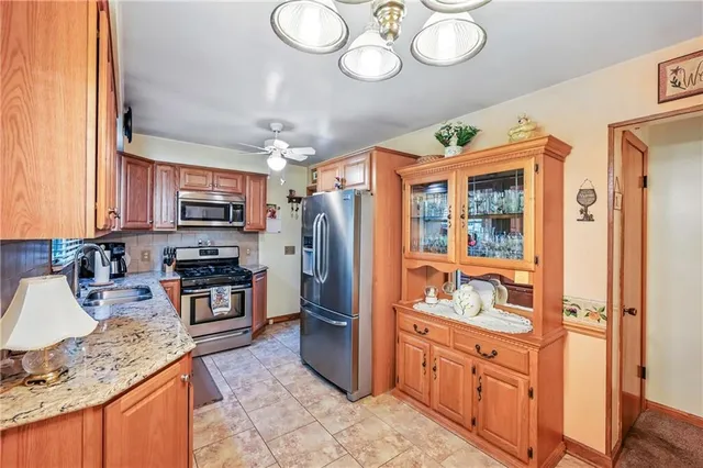 a kitchen with granite countertop stainless steel appliances a stove refrigerator and cabinets