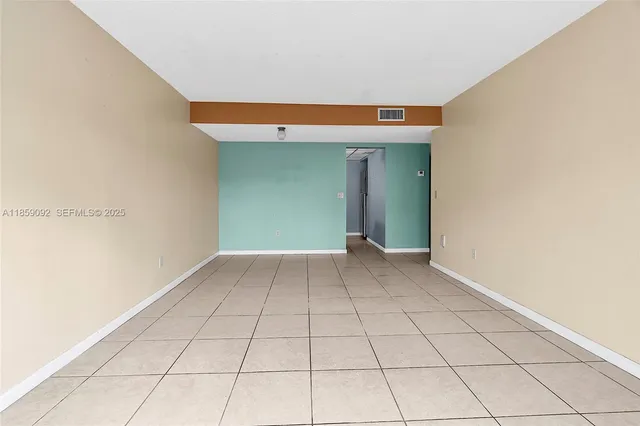 a view of a livingroom with an empty space and a window