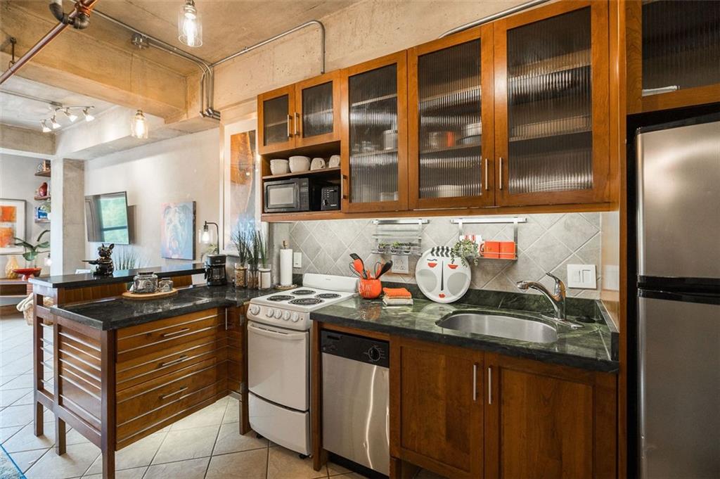 131 East Broad Street, Unit 503 Athens, GA 30601 - Photo 21 of 33 a kitchen with granite countertop a sink and cabinets