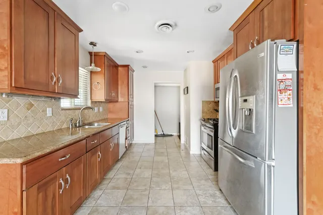 a kitchen with stainless steel appliances granite countertop a refrigerator and a sink