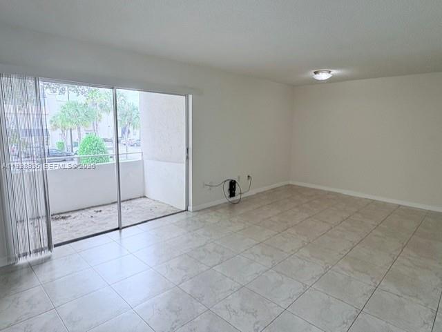 7785 Southwest 86th Street, Unit E219 Miami, FL 33143 - Photo 3 of 9 a view of an empty room with glass door