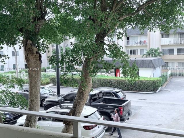 7785 Southwest 86th Street, Unit E219 Miami, FL 33143 - Photo 4 of 9 a view of a patio with table and chairs potted plants and a large tree