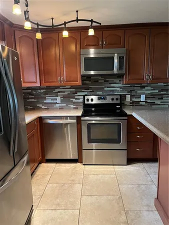 a kitchen with stainless steel appliances granite countertop a stove a microwave and a sink