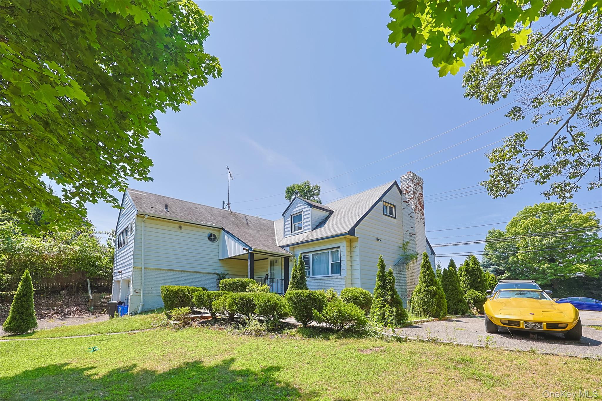 a front view of a house with a yard and potted plants
