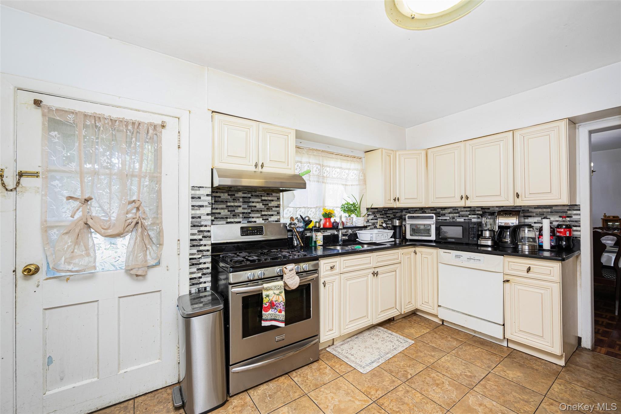 84 Middle Neck Road Roslyn, NY 11576 - Photo 12 of 44 a kitchen with white cabinets and appliances