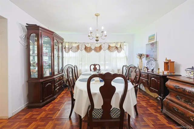 a view of a dining room with furniture a chandelier and wooden floor