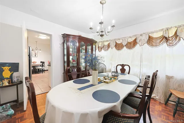 a view of a dining room with furniture a chandelier and wooden floor