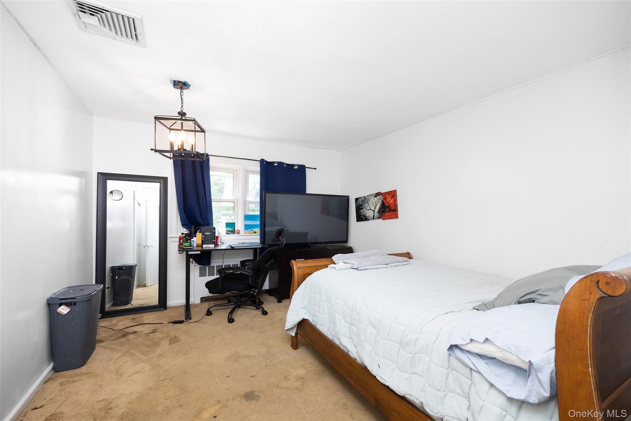 84 Middle Neck Road Roslyn, NY 11576 - Photo 23 of 44 a bedroom with a bed and a chandelier