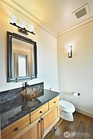 a bathroom with a granite countertop toilet a sink and mirror