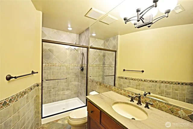 a bathroom with a sink shower and a mirror