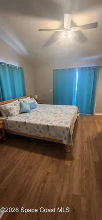 a bedroom with a bed and wooden floor
