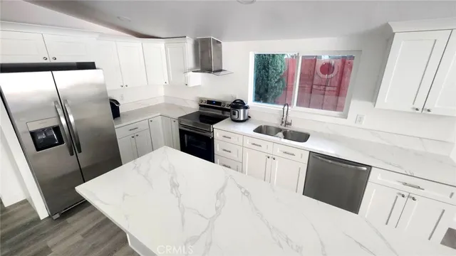 a kitchen with stainless steel appliances a refrigerator stove microwave and sink