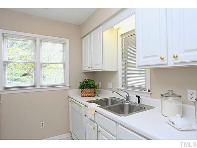 2821 Edridge Court, Unit 101 Raleigh, NC 27612 - Photo 13 of 25 a kitchen with granite countertop a sink a window and cabinets