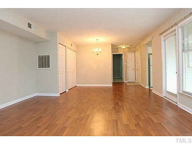 2821 Edridge Court, Unit 101 Raleigh, NC 27612 - Photo 3 of 25 a view of an empty room with wooden floor