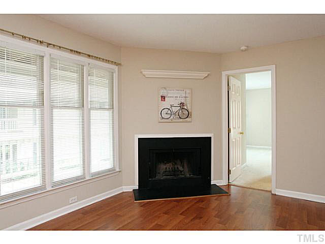 2821 Edridge Court, Unit 101 Raleigh, NC 27612 - Photo 6 of 25 a view of an empty room with a fireplace and a window