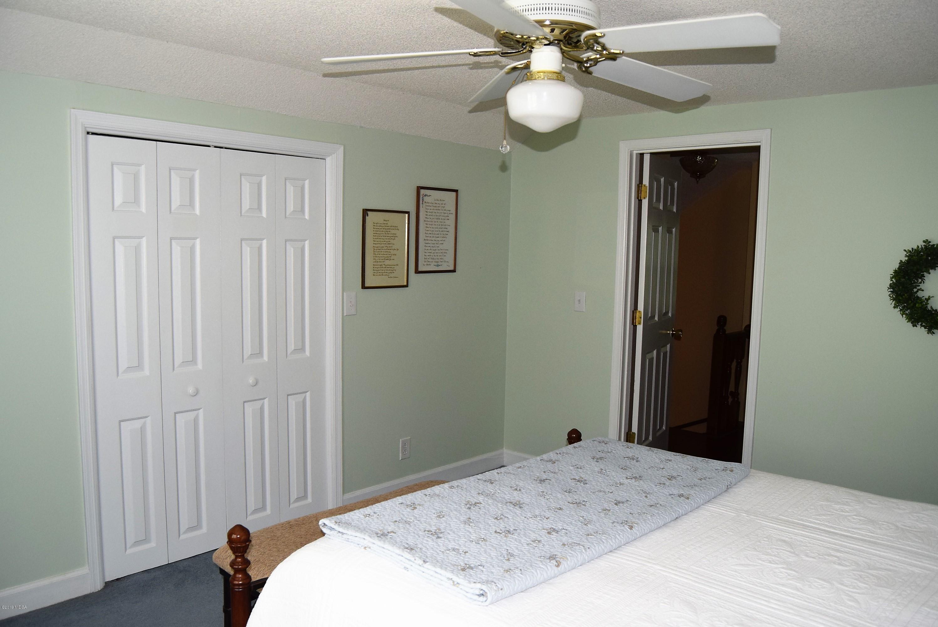 475 Stone Edge Road Macon, GA 31210 - Photo 21 of 36 a bedroom with a bed and a chandelier