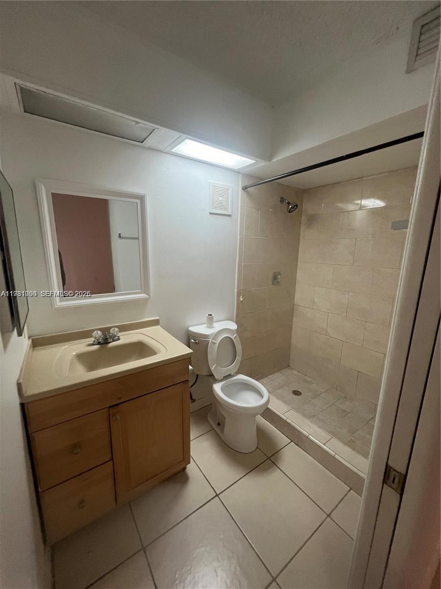 8500 Southwest 133rd Avenue Road, Unit 305 Miami, FL 33183 - Photo 5 of 7 a bathroom with a granite countertop sink toilet and shower