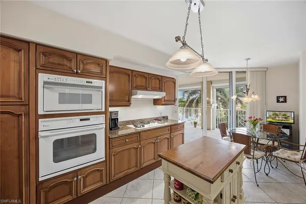 a dining room filled chandelier and wooden floor