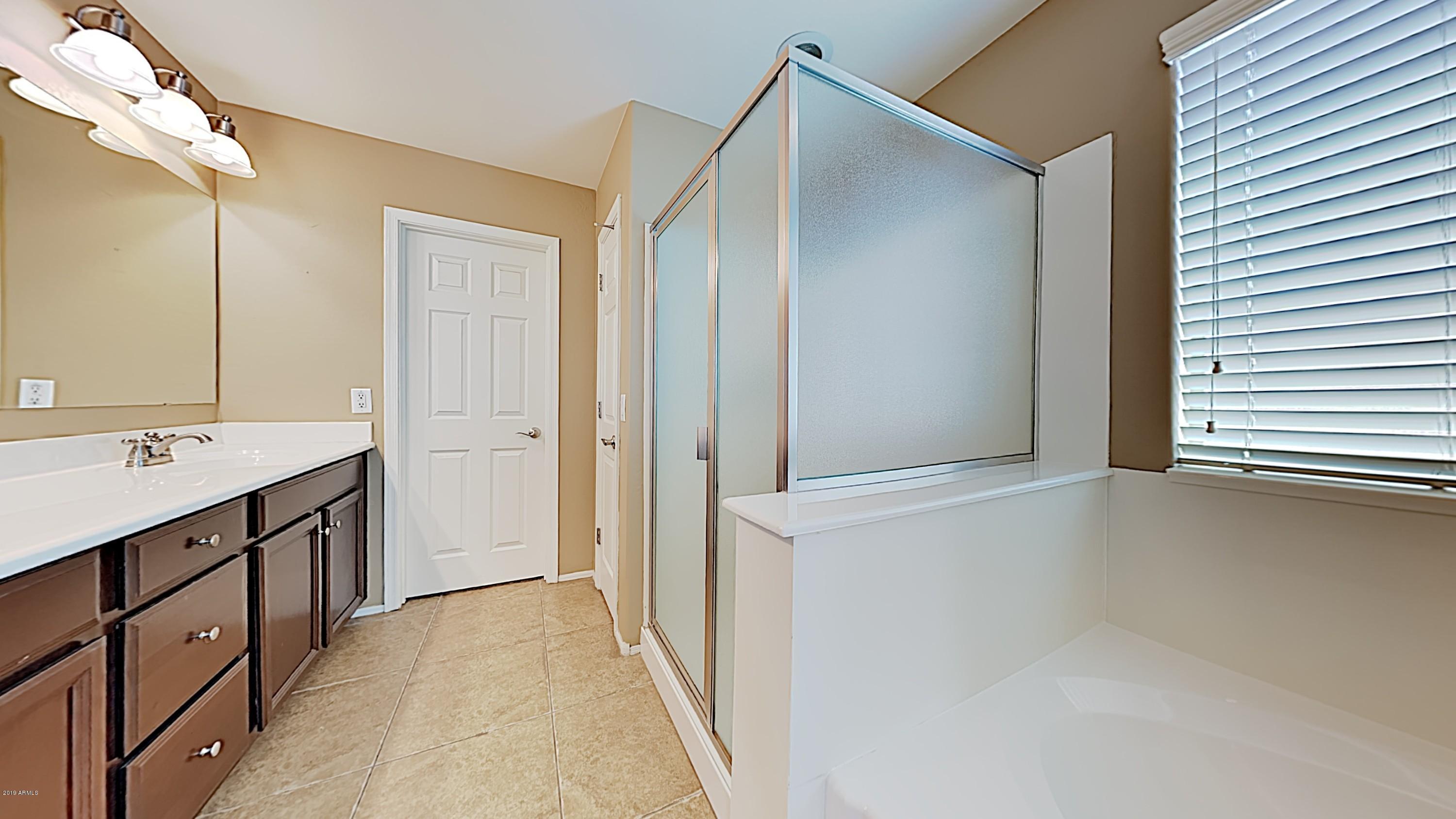2633 West Gaby Road Phoenix, AZ 85041 - Photo 10 of 17 a bathroom with a double vanity sink and mirror